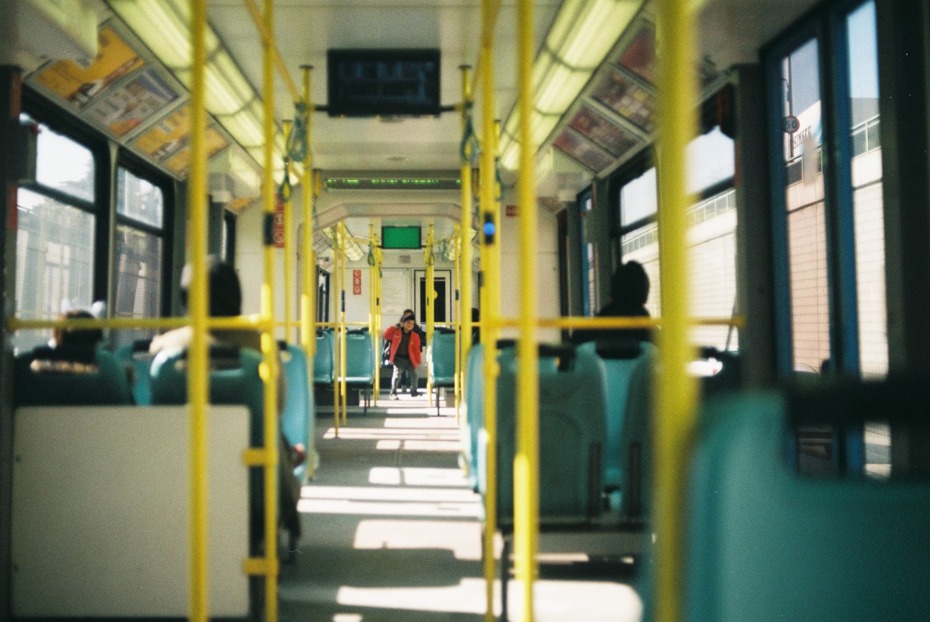 a person is sitting on a bus with yellow seats